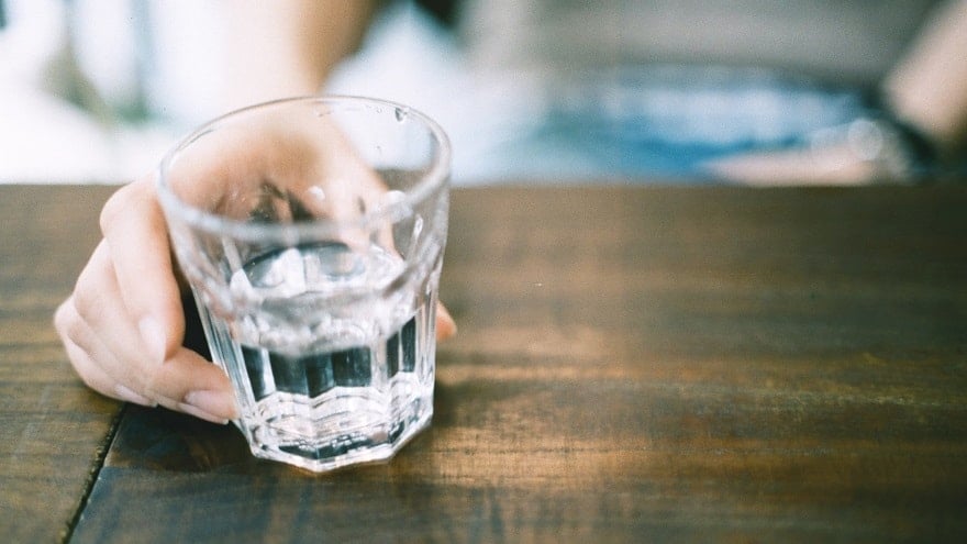 Hand on a glass of water