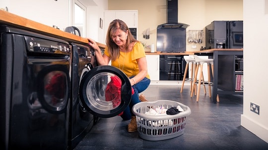 woman filling washing machine with clothes