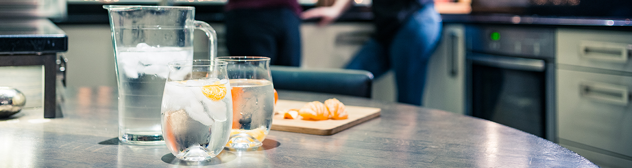 jug of water and glasses with orange slices